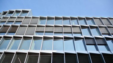 Camdan yapılmış bir ofis binasının parçası. Mavi gökyüzünün yansıması. 