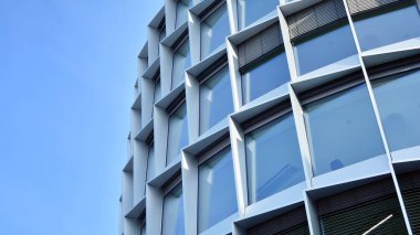 Camdan yapılmış bir ofis binasının parçası. Mavi gökyüzünün yansıması. 