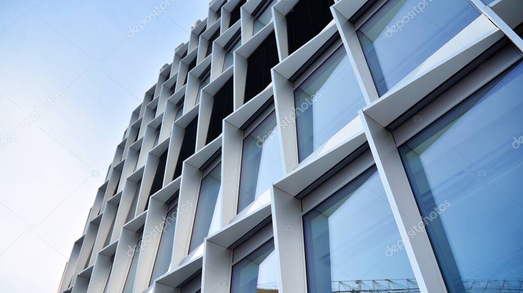 Fragment of an office building made of glass. The reflection of the blue sky. 