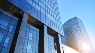 Şehir merkezindeki işletme bölgesi mimarisi. Mavi gökyüzüne ve güneş ışığına karşı cam yansıtıcı ofis binaları. Ekonomi, finans, iş faaliyeti kavramı.
