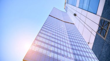 Şehir merkezindeki işletme bölgesi mimarisi. Mavi gökyüzüne ve güneş ışığına karşı cam yansıtıcı ofis binaları. Ekonomi, finans, iş faaliyeti kavramı.