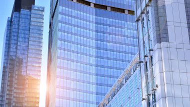 Şehir merkezindeki işletme bölgesi mimarisi. Mavi gökyüzüne ve güneş ışığına karşı cam yansıtıcı ofis binaları. Ekonomi, finans, iş faaliyeti kavramı.