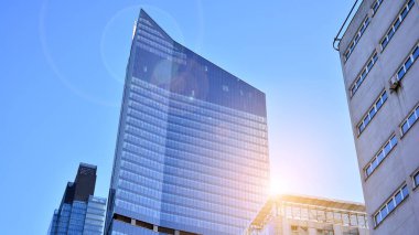 Şehir merkezindeki işletme bölgesi mimarisi. Mavi gökyüzüne ve güneş ışığına karşı cam yansıtıcı ofis binaları. Ekonomi, finans, iş faaliyeti kavramı.