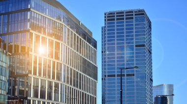 Şehir merkezindeki işletme bölgesi mimarisi. Mavi gökyüzüne ve güneş ışığına karşı cam yansıtıcı ofis binaları. Ekonomi, finans, iş faaliyeti kavramı.