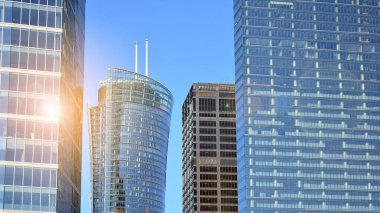 Şehir merkezindeki işletme bölgesi mimarisi. Mavi gökyüzüne ve güneş ışığına karşı cam yansıtıcı ofis binaları. Ekonomi, finans, iş faaliyeti kavramı.