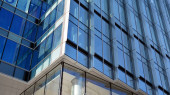 Fasádní textura skleněné zrcadlové kancelářské budovy. Krásné zázemí skleněné kancelářské budovy, odrážející mraky v oknech.