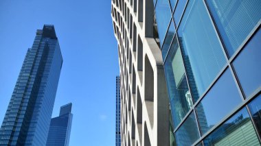 Cam aynalı ofis binasının ön dokusu. Camdan ofis binasının güzel bir arka planı, pencerelere yansıyan bulutlar..