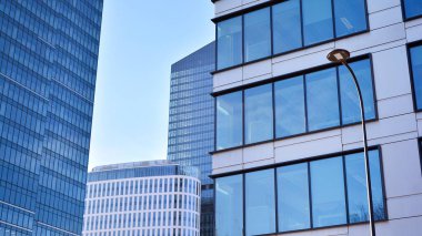 Cam aynalı ofis binasının ön dokusu. Camdan ofis binasının güzel bir arka planı, pencerelere yansıyan bulutlar..
