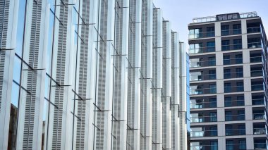 Cam aynalı ofis binasının ön dokusu. Camdan ofis binasının güzel bir arka planı, pencerelere yansıyan bulutlar..