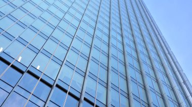 Cam aynalı ofis binasının ön dokusu. Camdan ofis binasının güzel bir arka planı, pencerelere yansıyan bulutlar..