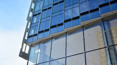 Cam aynalı ofis binasının ön dokusu. Camdan ofis binasının güzel bir arka planı, pencerelere yansıyan bulutlar..