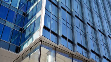 Cam aynalı ofis binasının ön dokusu. Camdan ofis binasının güzel bir arka planı, pencerelere yansıyan bulutlar..