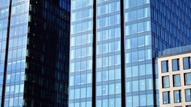 Bir gökdelenin cam cephesi. Modern ofis binası ve gökyüzü yansıması.