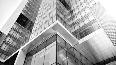 Modern gökdelenlerin gökyüzüne karşı alt görünümü. Şehir merkezindeki iş binalarına bakıyorum. Ufukta doğan güneş. Siyah ve beyaz.