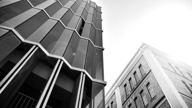 Yeniden canlandırılmış tuğla bina ve modern ofis binası. Ufukta doğan güneş. Siyah ve beyaz.