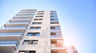 Apartman, ev ve dış görünüş mimarisi ve açık hava tesisleri. Arka planda mavi gökyüzü. Gün doğumunda gün ışığı.