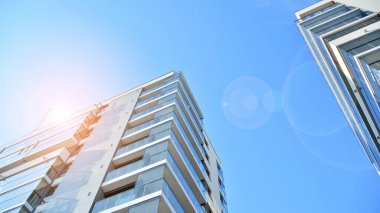 Apartman, ev ve dış görünüş mimarisi ve açık hava tesisleri. Arka planda mavi gökyüzü. Gün doğumunda gün ışığı.