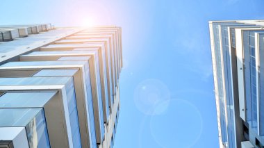 Apartman, ev ve dış görünüş mimarisi ve açık hava tesisleri. Arka planda mavi gökyüzü. Gün doğumunda gün ışığı.