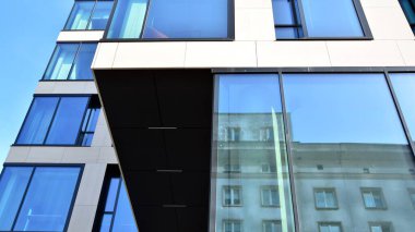 Modern bir ofis binasının cam ve kumtaşı cephesinin bir parçası. Modern bina cephesinin geniş ve soyut bir parçası. Modern cam ve taş cephe manzarası.