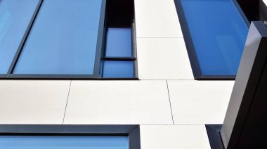 Modern bir ofis binasının cam ve kumtaşı cephesinin bir parçası. Modern bina cephesinin geniş ve soyut bir parçası. Modern cam ve taş cephe manzarası.