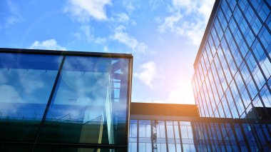 Gökyüzü arka planında cam cepheli modern ofis binası. Ofis binasının şeffaf cam duvarı.