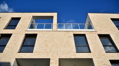 Öğleden sonra güneş batarken çekilmiş bir daire resmi. Mavi gökyüzüne karşı çağdaş beyaz konut binası. Gayrimenkul veya yatırım kavramlarının resmedilmesi için ideal.