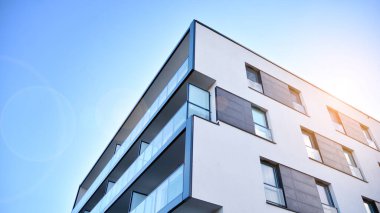 Öğleden sonra güneş batarken çekilmiş bir daire resmi. Mavi gökyüzüne karşı çağdaş beyaz konut binası. Gayrimenkul veya yatırım kavramlarının resmedilmesi için ideal.