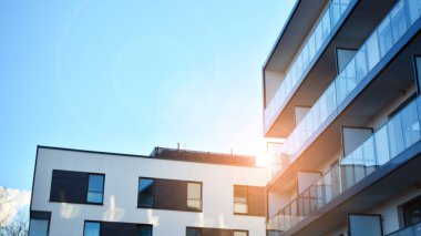 Öğleden sonra güneş batarken çekilmiş bir daire resmi. Mavi gökyüzüne karşı çağdaş beyaz konut binası. Gayrimenkul veya yatırım kavramlarının resmedilmesi için ideal.