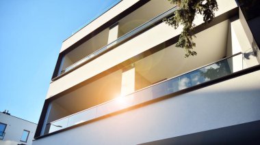 Öğleden sonra güneş batarken çekilmiş bir daire resmi. Mavi gökyüzüne karşı çağdaş beyaz konut binası. Gayrimenkul veya yatırım kavramlarının resmedilmesi için ideal.