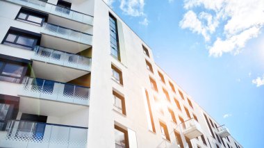 Modern bir apartmanın ön cephesi. Güneş ışığıyla cam yüzey. Güneşli bir günde, mavi gökyüzü olan modern apartmanlar..