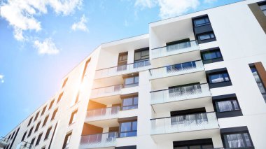 Modern bir apartmanın ön cephesi. Güneş ışığıyla cam yüzey. Güneşli bir günde, mavi gökyüzü olan modern apartmanlar..