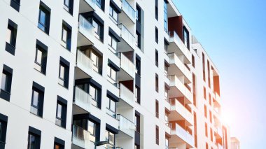 Modern bir apartmanın ön cephesi. Güneş ışığıyla cam yüzey. Güneşli bir günde, mavi gökyüzü olan modern apartmanlar..