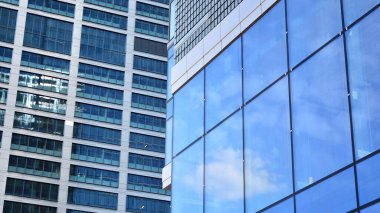 Yansıtıcı camlarla kaplı modern bir binanın cam ön cephesi..