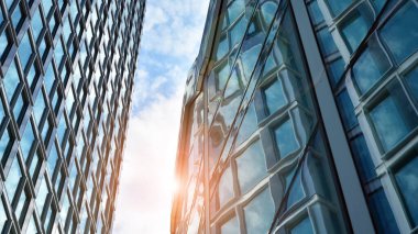 Yansıtıcı camlarla kaplı modern bir binanın cam ön cephesi..