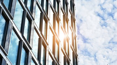 Yansıtıcı camlarla kaplı modern bir binanın cam ön cephesi..