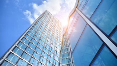 Yansıtıcı camlarla kaplı modern bir binanın cam ön cephesi..