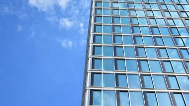 Yansıtıcı camlarla kaplı modern bir binanın cam ön cephesi..