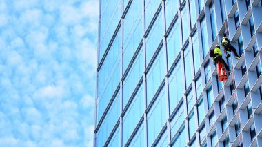 Yansıtıcı camlarla kaplı modern bir binanın cam kaplamalı dış cephesinin soyut yakın çekimi. Mimari soyut arkaplan. Cam duvar ve ön cephe ekibi. Velvia grafik filtresi.