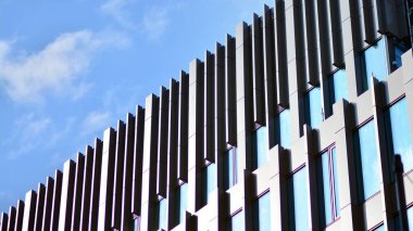 Gökyüzü yansıyan bir ofis binasının camlı cephesi. Modern mimari binalar dış plan. Bulutlar gökyüzü yansıması.