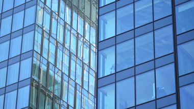 Gökyüzü yansıyan bir ofis binasının camlı cephesi. Modern mimari binalar dış plan. Bulutlar gökyüzü yansıması.
