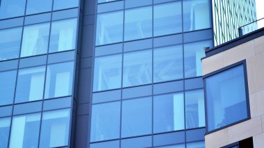 Gökyüzü yansıyan bir ofis binasının camlı cephesi. Modern mimari binalar dış plan. Bulutlar gökyüzü yansıması.