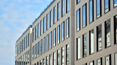 Gökyüzü yansıyan bir ofis binasının camlı cephesi. Modern mimari binalar dış plan. Bulutlar gökyüzü yansıması.