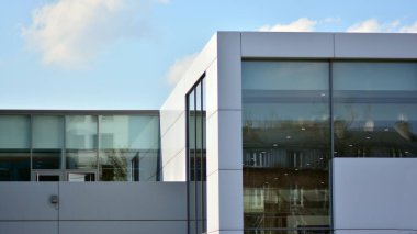 Gökyüzü yansıyan bir ofis binasının camlı cephesi. Modern mimari binalar dış plan. Bulutlar gökyüzü yansıması.