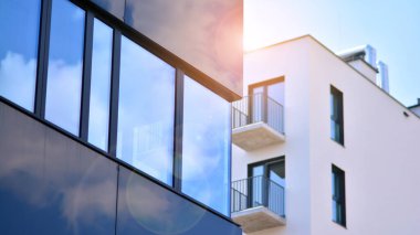 Binanın cam cephesinde mavi gökyüzü yansıması. Gün doğumu, yansıma ve perspektif ile kapalı ofis binası pencereleri mavi gökyüzünde güneş ışınları ile aydınlık bir günde cam cephe. 