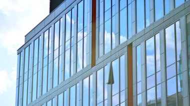 Gökyüzü yansıyan bir ofis binasının camlı cephesi. Modern mimari binalar dış plan. Bulutlar gökyüzü yansıması.