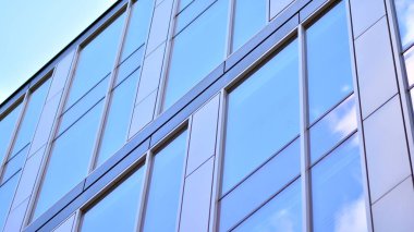 Gökyüzü yansıyan bir ofis binasının camlı cephesi. Modern mimari binalar dış plan. Bulutlar gökyüzü yansıması.