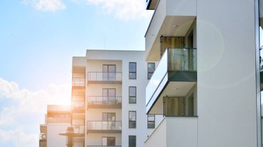 Yeni lüks ev ve kompleksin ayrıntıları. Güneş ışığıyla cam yüzey. Ufukta doğan güneş. Düz binalı, modern apartman dairesinin bir parçası.. 