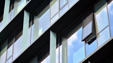 Mavi gökyüzü olan binaların cam cephesi. Şehir merkezindeki gökdelenler modern cam binaların arka planı.. 