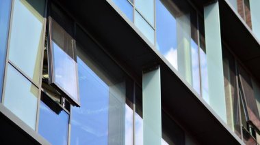 Mavi gökyüzü olan binaların cam cephesi. Şehir merkezindeki gökdelenler modern cam binaların arka planı.. 