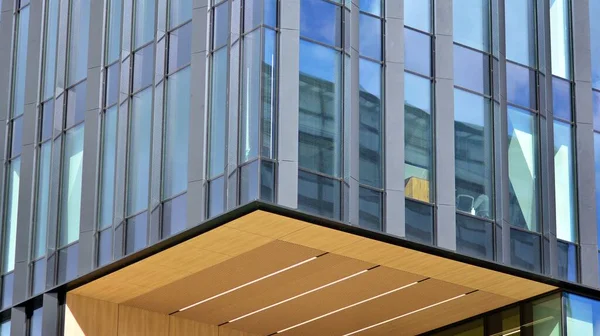 Modern office building detail, glass surface on a clear sky background. Transparent glass wall of office building.